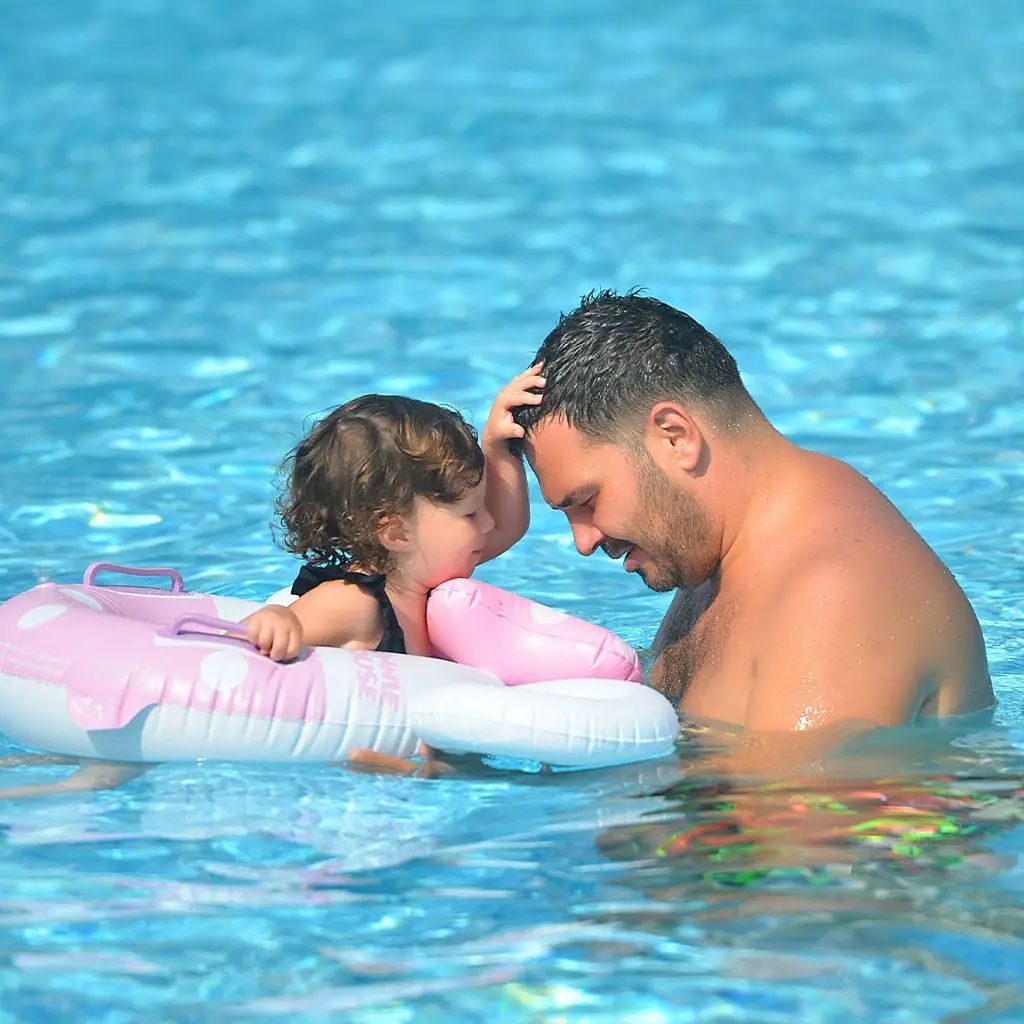 This photo of a baby is a floatie with an adult is for decorative purposes.