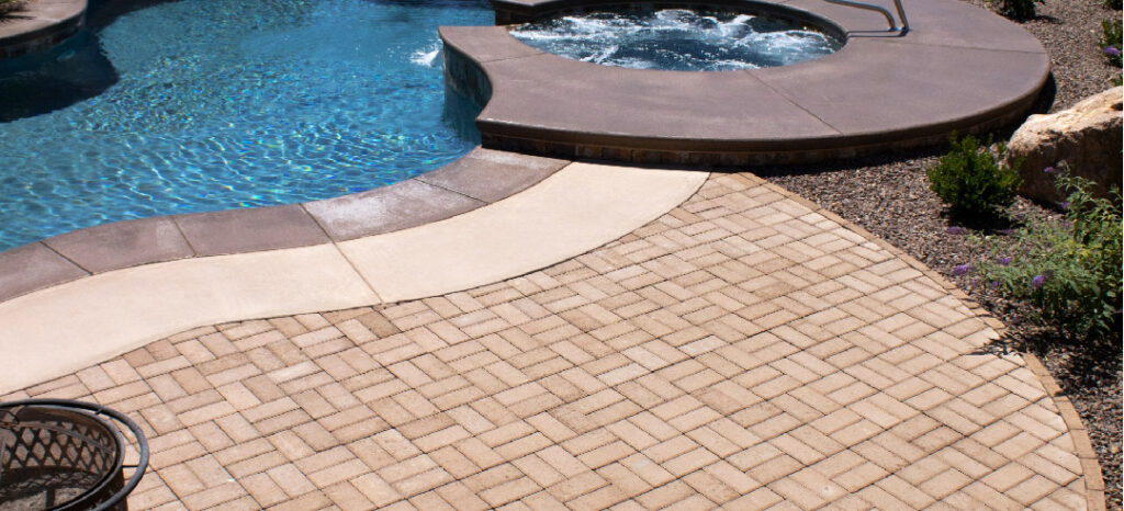 An example of installed pavers deck by a fiberglass pool.