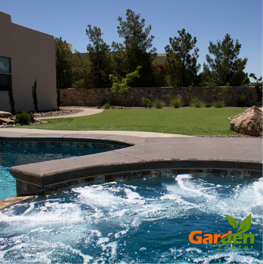 A pool and hot tub shown newly installed in a backyard by Pools by Garden Center.