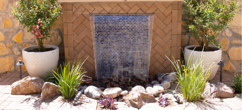 A pondless wall water feature seen working in a backyard.